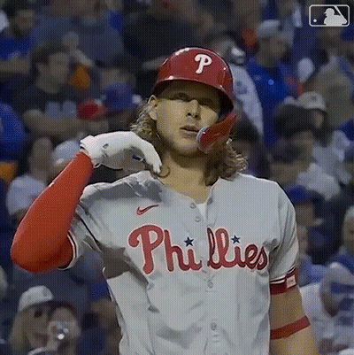 A Phillies Baseball Player Is Wearing A Red Helmet And A White Shirt . GIF