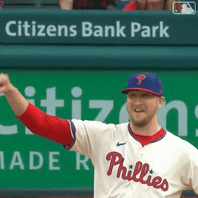 A Phillies Baseball Player Stands In Front Of A Citizen 'S Bank Park Banner GIF