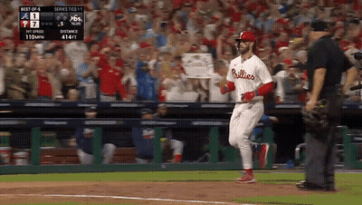 A Phillies Player Is Running Towards Home Plate During A Baseball Game GIF
