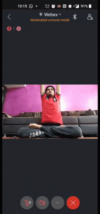A Phone Screen Shows A Man Sitting In A Lotus Position With His Arms Up GIF