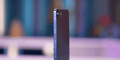 A Phone With A Camera On The Back Is Sitting On A Table GIF