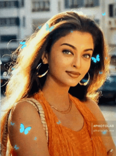 A Photo Of A Woman With Blue Butterflies Flying Around Her GIF