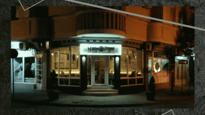 A Picture Of A Building With A Sign That Says Happy Pipe GIF