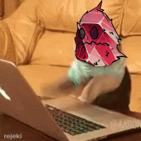 A Picture Of A Cat Using A Laptop With A Drawing Of A Monster On It GIF