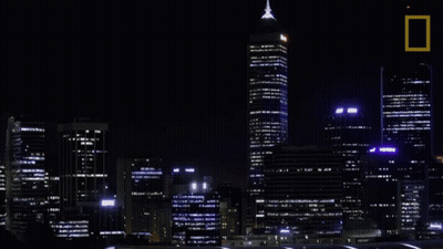 A Picture Of A City At Night With A National Geographic Logo GIF