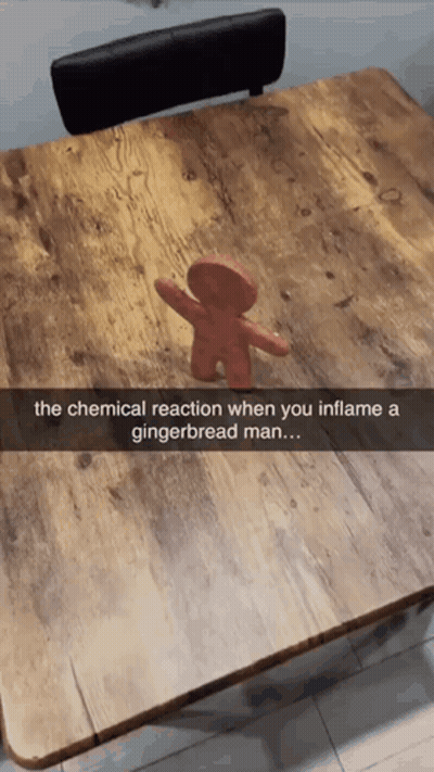 A Picture Of A Gingerbread Man On A Wooden Table GIF