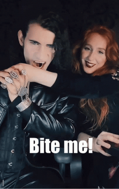 A Picture Of A Man Biting A Woman 'S Hand With The Words Bite Me Below It GIF