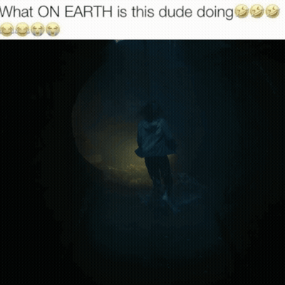 A Picture Of A Man Holding A Flashlight In A Dark Room With The Caption What On Earth Is This Dude Doing GIF