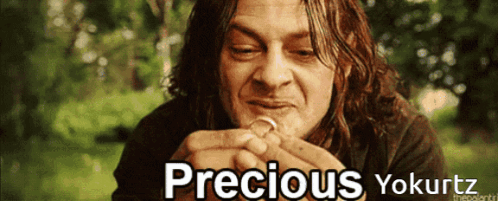 A Picture Of A Man Holding A Ring With The Words Precious Yokurtz Above Him GIF