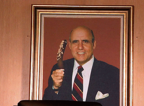 A Picture Of A Man In A Suit And Tie Holding A Cane GIF