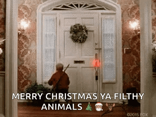 A Picture Of A Man Standing In Front Of A Door With The Words Merry Christmas Ya Filthy Animals On It GIF