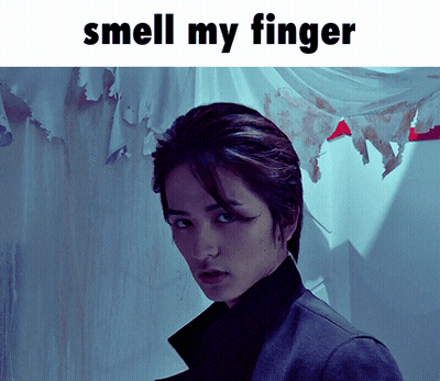 A Picture Of A Man With The Words " Smell My Finger " Above Him GIF