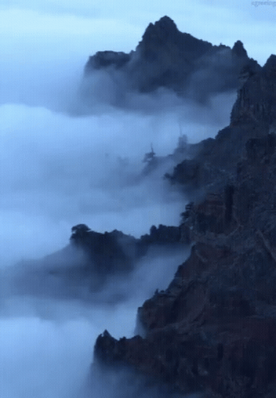 A Picture Of A Mountain Covered In Clouds With The Words Agreeing Below It GIF