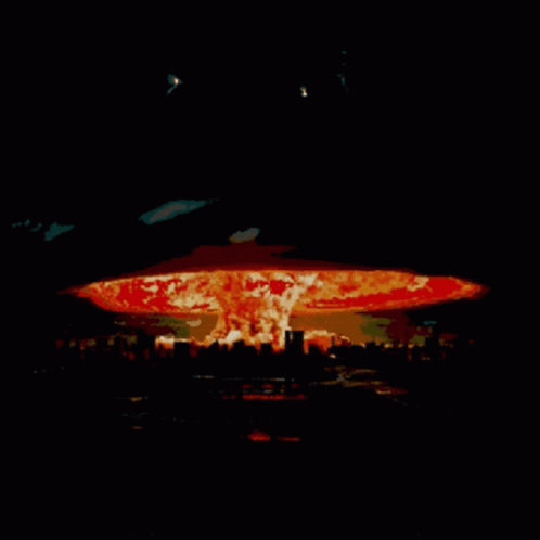 A Picture Of A Nuclear Explosion With A City In The Foreground GIF