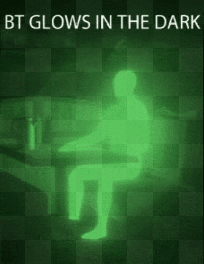 A Picture Of A Person Sitting At A Table That Is Glowing In The Dark GIF