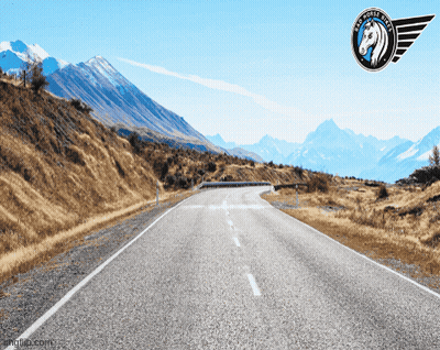 A Picture Of A Road With Mountains In The Background And A Logo That Says Big Horse Tires GIF