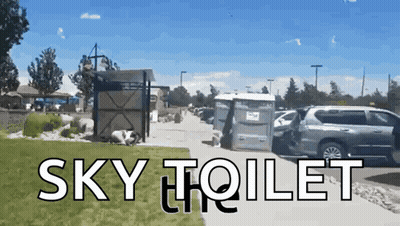A Picture Of A Sky Toilet With A Van Parked In Front Of It GIF