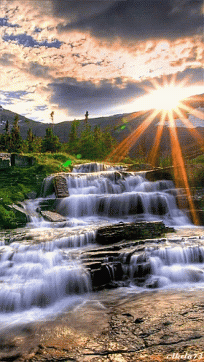 A Picture Of A Waterfall With The Sun Shining Through The Clouds And The Number 73 On The Bottom GIF