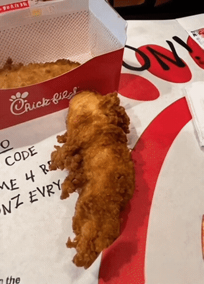 A Piece Of Fried Chicken Sits On A Table Next To A Chick Fil A Box GIF