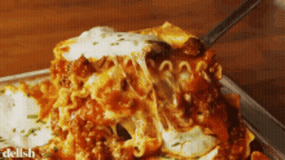 A Piece Of Lasagna Is Being Eaten With A Fork GIF