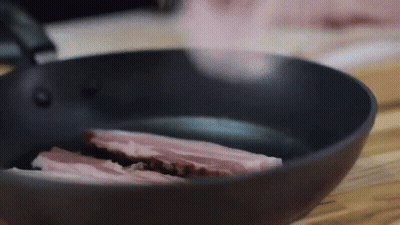 A Piece Of Meat Is Being Cooked In A Frying Pan GIF