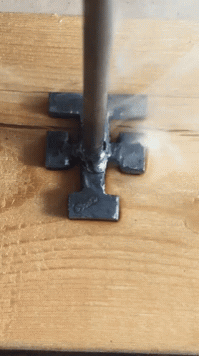 A Piece Of Metal That Looks Like A Hammer Is On A Wooden Surface GIF