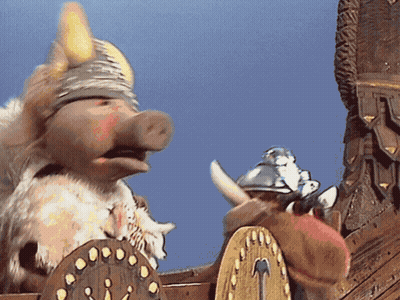 A Pig Wearing A Viking Helmet Is Standing Next To A Shield GIF