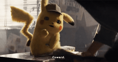 A Pikachu Wearing A Hat Says Coward While Standing On A Table GIF