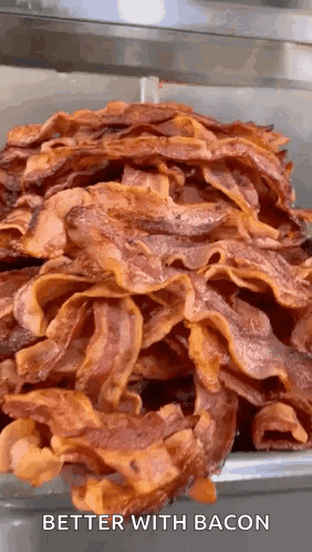 A Pile Of Bacon Is Sitting On Top Of Each Other On A Table . GIF