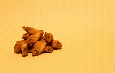 A Pile Of Chicken Wings Next To A Pile Of Chicken Bones On A Yellow Background GIF