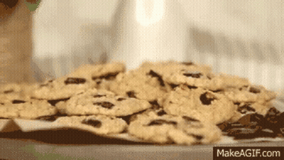 A Pile Of Chocolate Chip Cookies On A Table With Makeagif.com Written On The Bottom Right GIF
