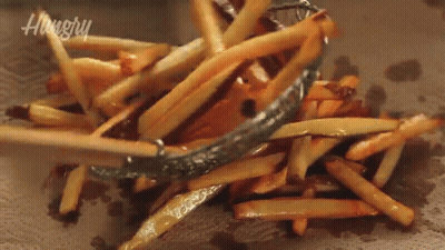 A Pile Of French Fries Are Being Scooped Out Of A Bowl With A Hungry Logo In The Background GIF