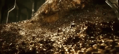 A Pile Of Gold Coins Is Sitting On Top Of A Pile Of Dirt And Rocks . GIF