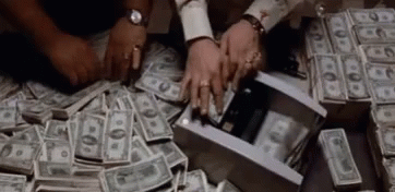 A Pile Of Money Is Being Taken Out Of A Box By Two People . GIF