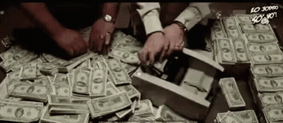 A Pile Of Money Is On A Table And People Are Counting It . GIF