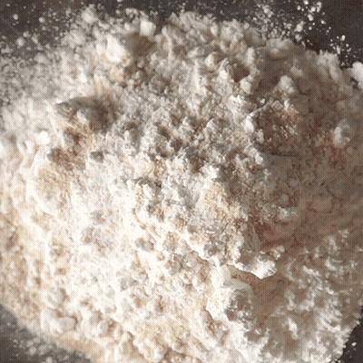 A Pile Of White Powder Is Sitting On A Gray Surface GIF