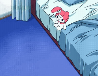 A Pink And White Stuffed Animal Is Sitting On A Bed With Blue Sheets GIF