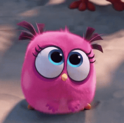 A Pink Angry Bird With Big Blue Eyes Is Sitting On The Ground GIF