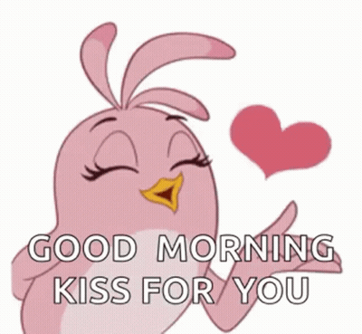 a pink cartoon bird is blowing a kiss with a heart in its beak .