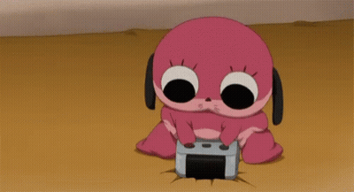 A Pink Cartoon Character Is Sitting On The Ground Holding A Video Game Controller GIF