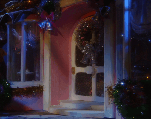 A Pink House With A White Door And A Wreath On It GIF