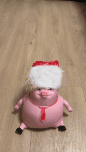 A Pink Stuffed Animal Is Crawling On A Wood Floor GIF