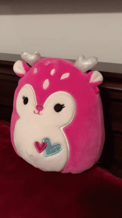 A Pink Stuffed Animal With Silver Antlers And Hearts On Its Face GIF