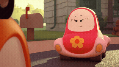 A Pink Toy Car With A Flower On The Front Is Sitting On The Street GIF