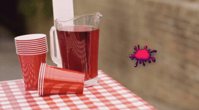 A Pitcher Of Red Liquid Sits On A Checkered Table Cloth GIF