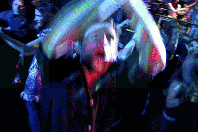 A Pixelated Image Of A Crowd Of People Dancing In A Dark Room GIF