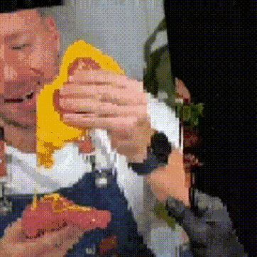 A Pixelated Image Of A Man Holding A Piece Of Pizza GIF