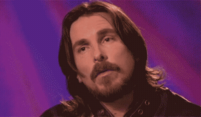A Pixelated Image Of A Man With Long Hair And A Beard Against A Purple Background GIF