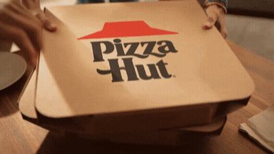 A Pizza Hut Box Sitting On A Wooden Table GIF