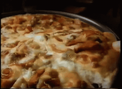 A Pizza With A Lot Of Toppings Is Being Eaten GIF